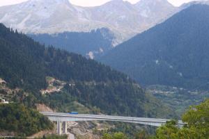 a bridge in the mountains with a train on it at Baou House 1 in Metsovo