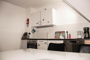 a kitchen with white cabinets and a counter top at Planet Gast - Beatles-Wohnung in Marklohe