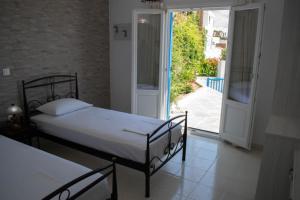 - une chambre avec un lit et une porte ouverte dans l'établissement Kouki Maria Rooms, à Apollonia