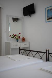a bedroom with a bed and a tv on the wall at Kouki Maria Rooms in Apollonia