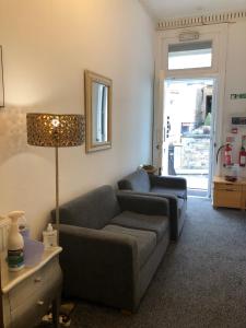 a living room with two couches and a lamp at Renfrew rooms at City Centre in Glasgow