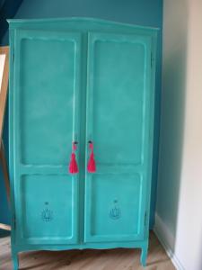 un armadio blu con due porte e nappe rosse di Slaaphuisje Het vliegend varken a Genk