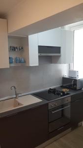 uma cozinha com um lavatório e um fogão forno superior em Water Lily Apartment - self check-in em Oradea