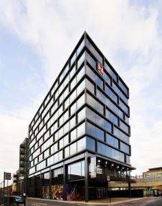 a tall black building with a sign on it at citizenM London Shoreditch in London