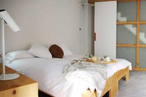 ナヴァタにあるCan Girmas Casa de Turisme rural Navataのテーブル付きの客室で、白い大型ベッド1台が備わります。