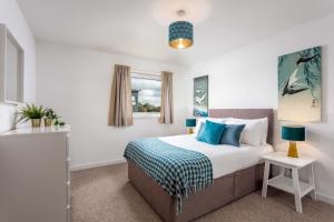 een slaapkamer met een groot bed met blauwe kussens bij Walker Suite No53 - Donnini Apartments in Kilmarnock