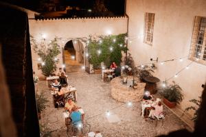a group of people sitting at tables in a restaurant at Relais Convento Santa Croce in SantʼAnatolia di Narco