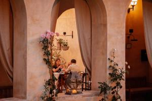 Ex Convento Santa Croce-Country resort في SantʼAnatolia di Narco: يجلس شخصان على طاولة في مبنى