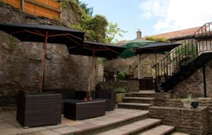 un patio con mesas y sombrillas en un edificio en Woolpack Inn by Greene King Inns, en Frome