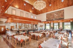 a restaurant with tables and chairs and a chandelier at Apartamentos Lomas De Campoamor in Campoamor