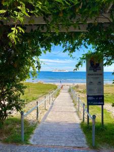 ein Weg zum Strand mit einem Schild in der Unterkunft Villa Vogue Gretas Beach Home in Binz