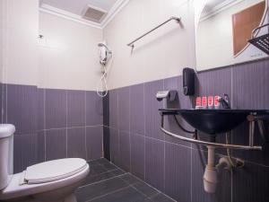 a bathroom with a toilet and a sink at Super OYO 89363 Casavilla Hotel in Batu Caves