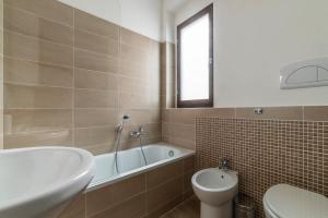 a bathroom with a tub and a toilet and a sink at Fonte Laurentina Apartments in Rome