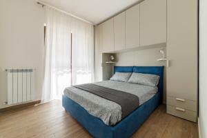 a bedroom with a blue bed and white cabinets at Fonte Laurentina Apartments in Rome