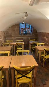a dining room with wooden tables and yellow chairs at The Silk House in Leek