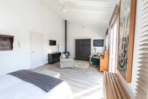 a white bedroom with a bed and a desk at Long House Ses Salines in Ses Salines