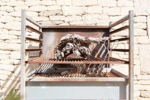 un estante de metal con comida junto a una pared de ladrillo en Casa con piscina privada en el sur de Mallorca, en Ses Salines