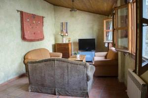a living room with a couch and a tv at Casa Plana Calasanz in Calasanz
