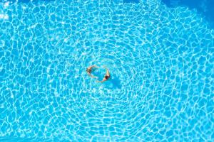 a person swimming in a pool of water at Hotel Kriopigi in Kriopigi