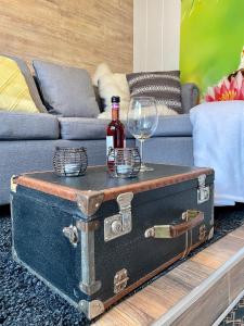 an old trunk with a bottle of wine and a glass at Die Pilgerbox, Tiny House trifft Urlaub in Dahlem