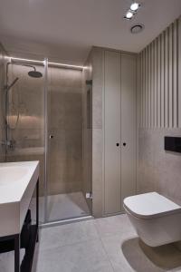 a bathroom with a shower and a toilet and a sink at Seaside Park Apartament Prywatny 405 z widokiem na morze in Kołobrzeg