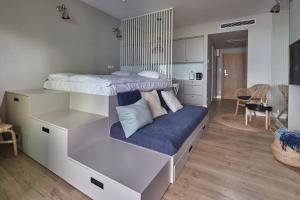 a bedroom with a bunk bed with a blue couch at Seaside Park Apartament Prywatny 405 z widokiem na morze in Kołobrzeg