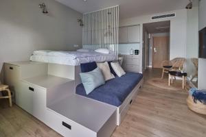 - une chambre avec des lits superposés et un canapé bleu dans l'établissement Seaside Park Apartament Prywatny 405 z widokiem na morze, à Kołobrzeg