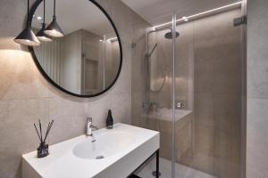 une salle de bain avec un lavabo, un miroir et une douche dans l'établissement Seaside Park Apartament Prywatny 405 z widokiem na morze, à Kołobrzeg 4 autres photos