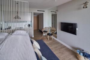 a bedroom with a bed and a flat screen tv at Seaside Park Apartament Prywatny 405 z widokiem na morze in Kołobrzeg