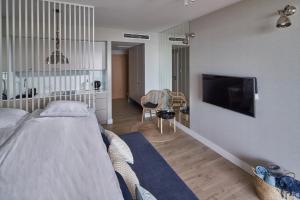une chambre avec un lit et une télévision à écran plat dans l'établissement Seaside Park Apartament Prywatny 405 z widokiem na morze, à Kołobrzeg
