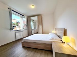 um quarto com uma cama com um candeeiro e uma janela em Santa Caterina em Levanto