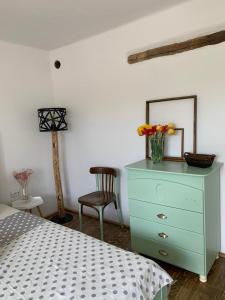 a bedroom with a blue dresser with a mirror and a chair at Guest House Victoria in Galda de Jos +9 photos