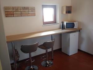 科萊薩爾韋蒂的住宿－B & B CUORE TOSCANO，厨房配有带2张凳子的台面和微波炉