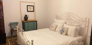 a bedroom with a white bed with pillows and a dresser at Guest House Victoria in Galda de Jos