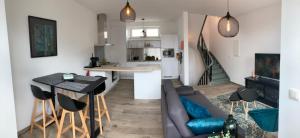 a living room and kitchen with a couch and a table at Les Duplex de la Place des Ecoles in Spa
