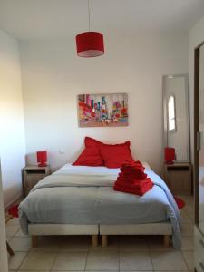 a bedroom with a bed with red pillows on it at villa claire de lune la Nartelle in Sainte-Maxime
