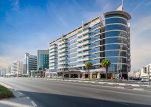 een hoog gebouw aan de kant van een stadsstraat bij Star Metro Deira Hotel Apartments in Dubai