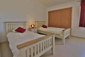a bedroom with two beds with red pillows on them at Casa Vale Do Lobo 832A - Charming Townhouse AC few minutes walk from Beach Praca in Vale do Lobo