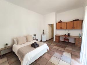 ein Schlafzimmer mit einem Bett und Fliesenboden in der Unterkunft Bezalel Wine & Brandy Estate in Kanoneiland
