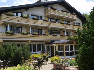 a hotel with tables and chairs in front of it at Ferienhotel Schwarzwälder Hof in Feldberg
