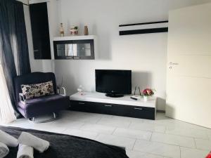 a living room with a tv and a chair at Brasov 3C DELUX 2 in Braşov