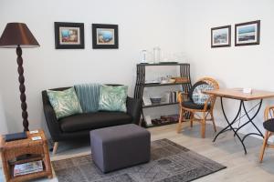 a living room with a chair and a table at Beach Break B&B - Solar Powered in Port Alfred