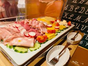 una bandeja de comida con carnes y verduras en una mesa en Landhaus Hammoor, en Hammoor