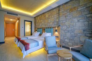 a bedroom with two beds and a stone wall at Cape Krio Boutique Hotel & SPA - Over 12 years old Adult Only in Datca +74 photos