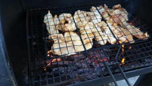 a bunch of food cooking on a grill at Kamilla Vendégház in Ács