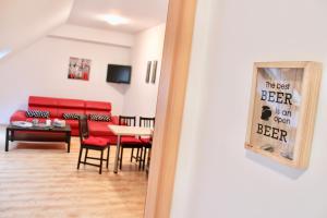 un miroir reflétant le salon avec un canapé rouge dans l'établissement City Center Apartman Miskolc, à Miskolc