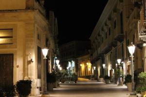 una calle vacía por la noche con luces de calle en La Casa del Nespolo, en Ragusa