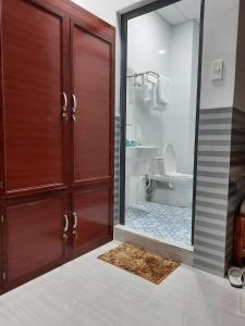 a bathroom with a wooden door and a toilet at Hotel Sen Việt Bạc Liêu in Bạc Liêu