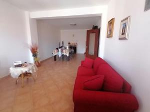 sala de estar con sofá rojo y mesa en Domus giuseppe, en Guardiabruna