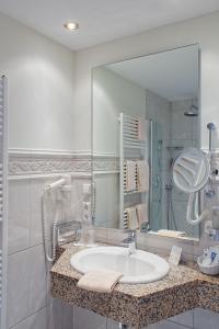 a bathroom with a sink and a large mirror at Golfpark Gut Düneburg in Haren